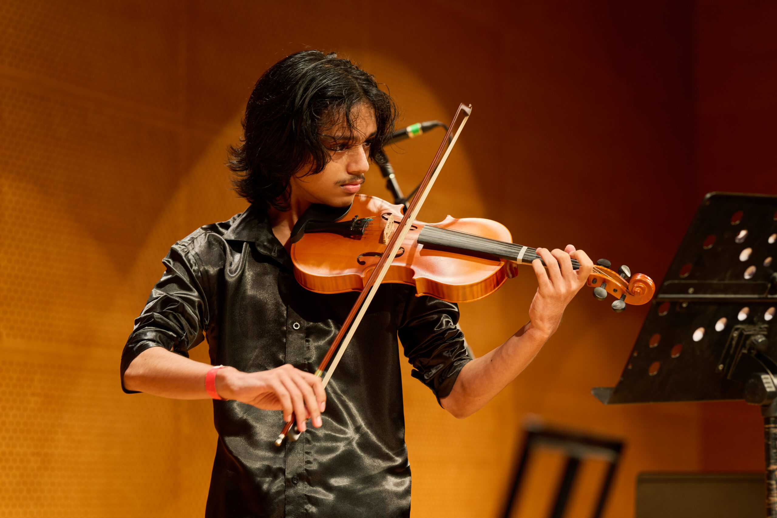 Laudem student performing violin on stage